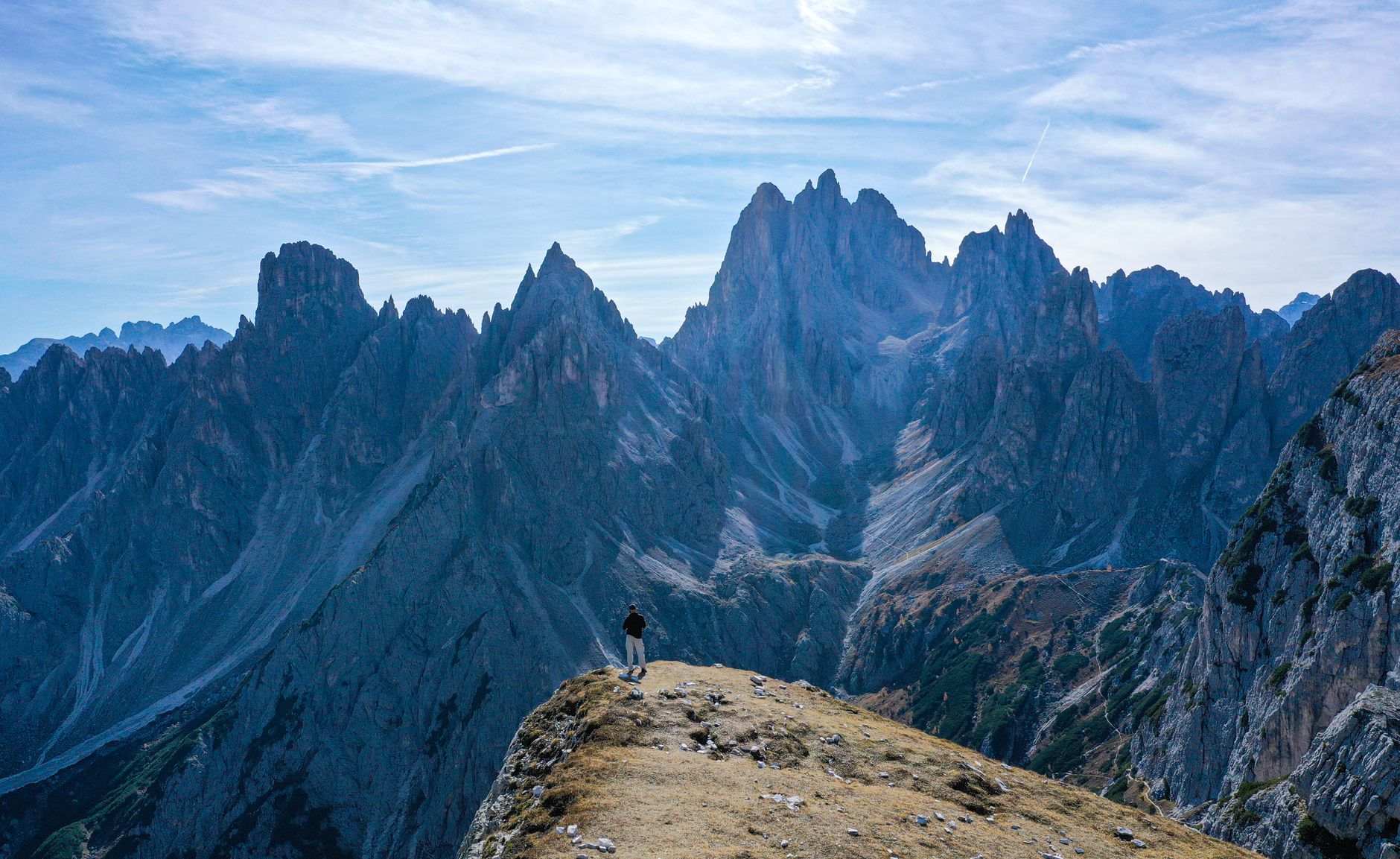 Hiker gazing over panoramic mountain ridges under sunlight