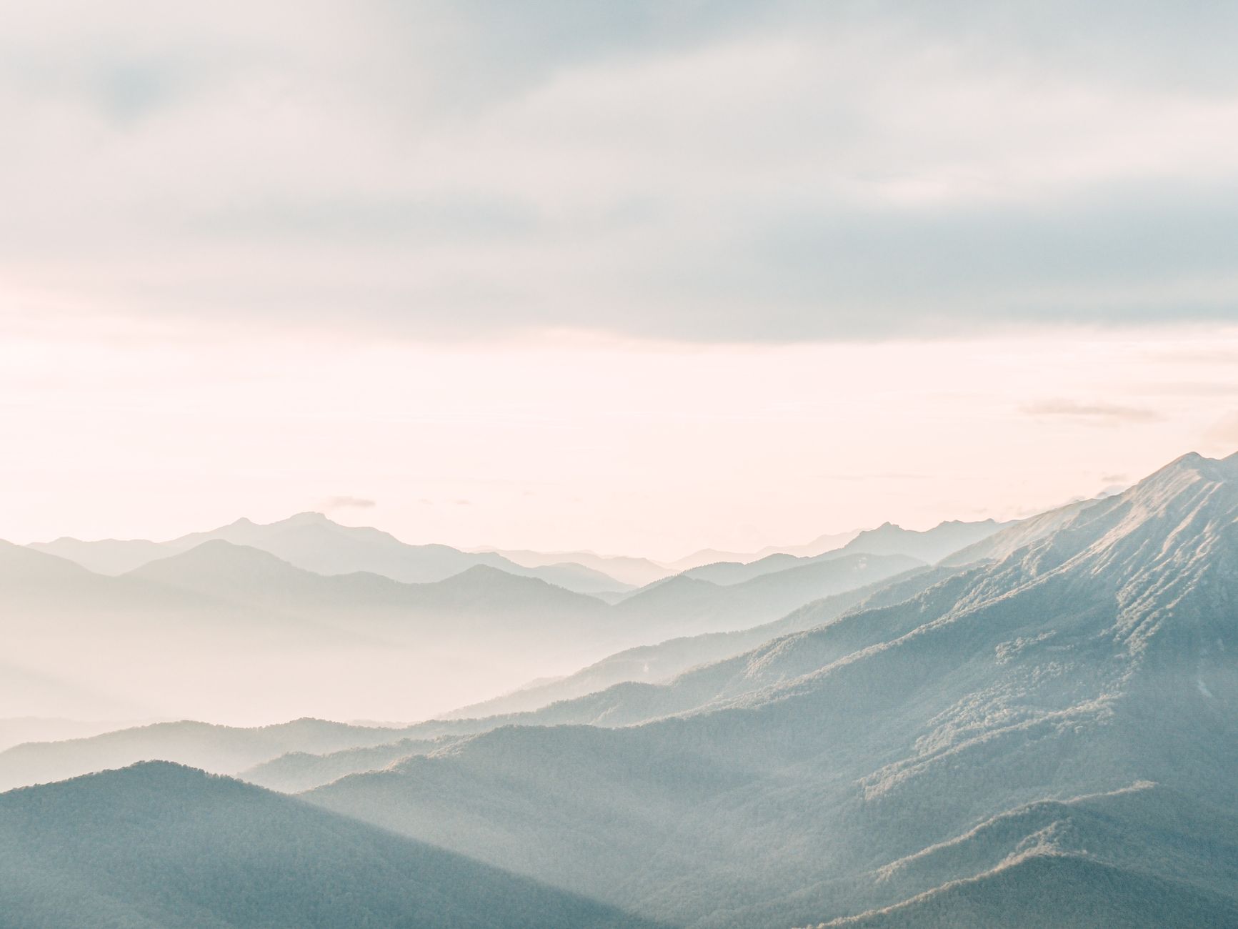 Quiet mist enveloping a remote mountain valley at dawn